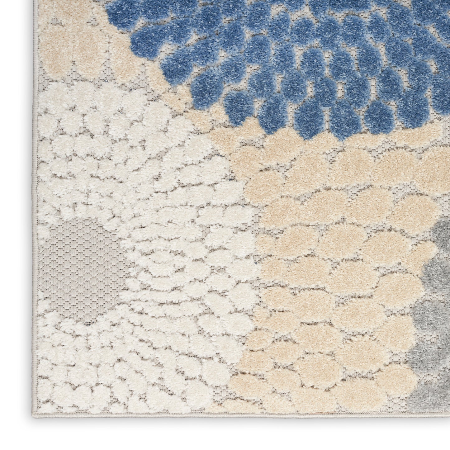Blue, beige and cream tufted rug with circular cluster motifs in a patchwork, shag-like texture.