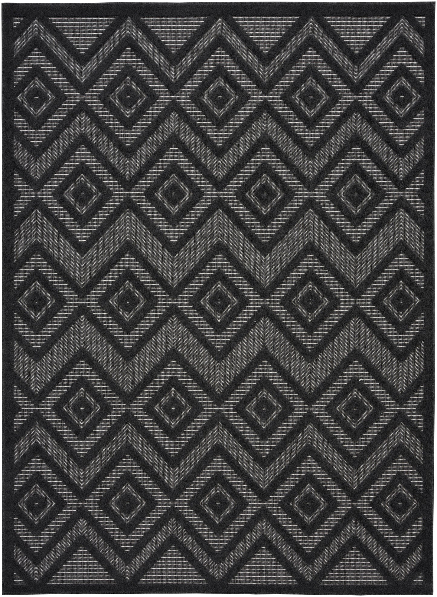 Dark charcoal rug with a repeating gray geometric diamond and chevron pattern in a woven texture.