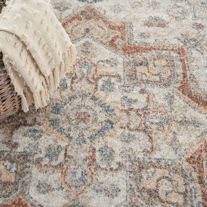 Muted oriental rug in cream, blue and rust with motifs.