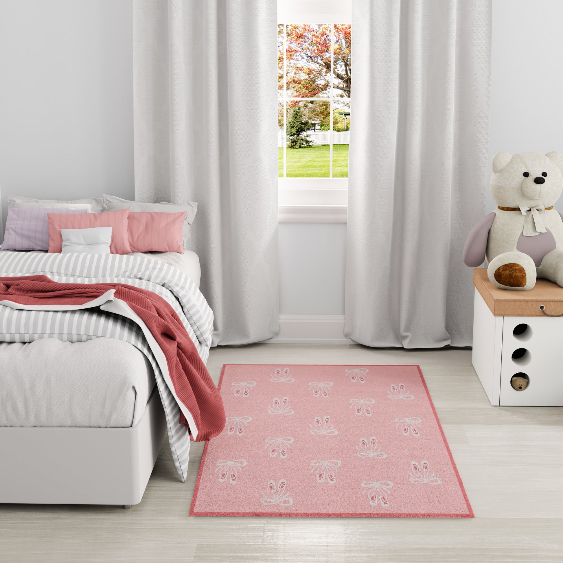 Pink rug with white bunny prints in a light gray bedroom; white curtains and a teddy on the dresser.