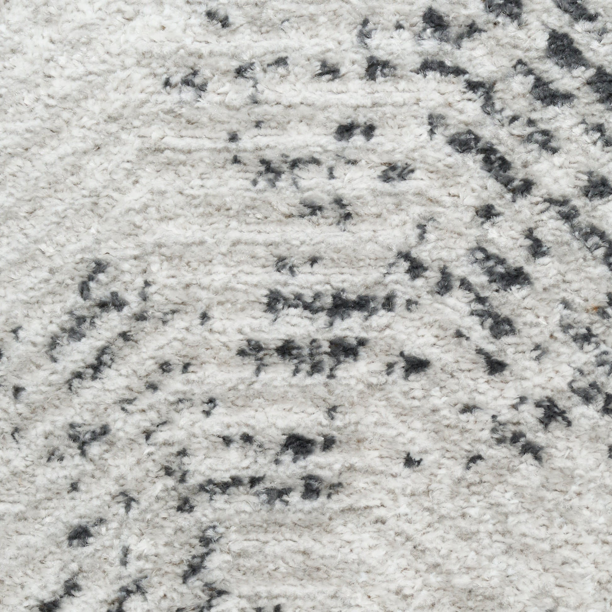 Cream shag rug with dark gray abstract pattern and plush pile.