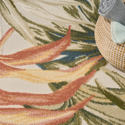 Colorful palm-leaf rug in beige, green, orange, and yellow; round wicker basket with folded blue-gray and mint fabrics.