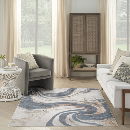 Living room with blue-gray abstract swirl rug, gray armchair, white sofa, wicker cabinet, cream curtains, and greenery.