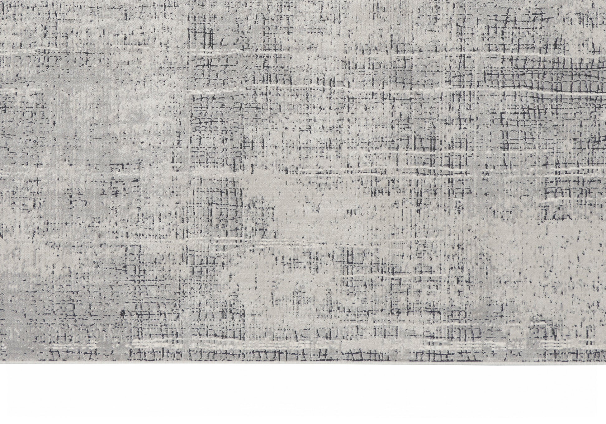 Rectangular area rug in muted gray tones with an abstract distressed pattern and subtle speckling.