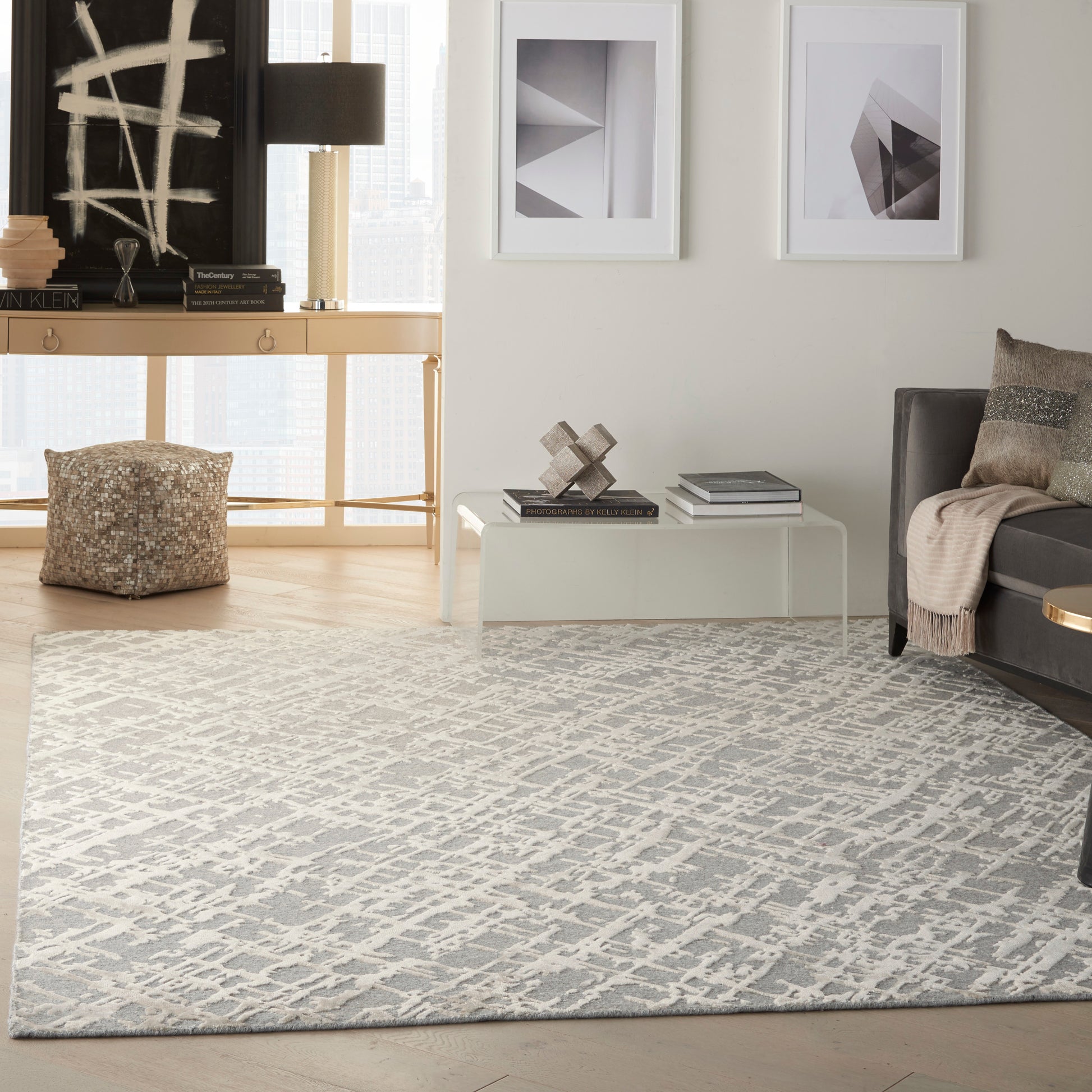 Gray and white geometric area rug in a contemporary living room with light wood floor and neutral accents.