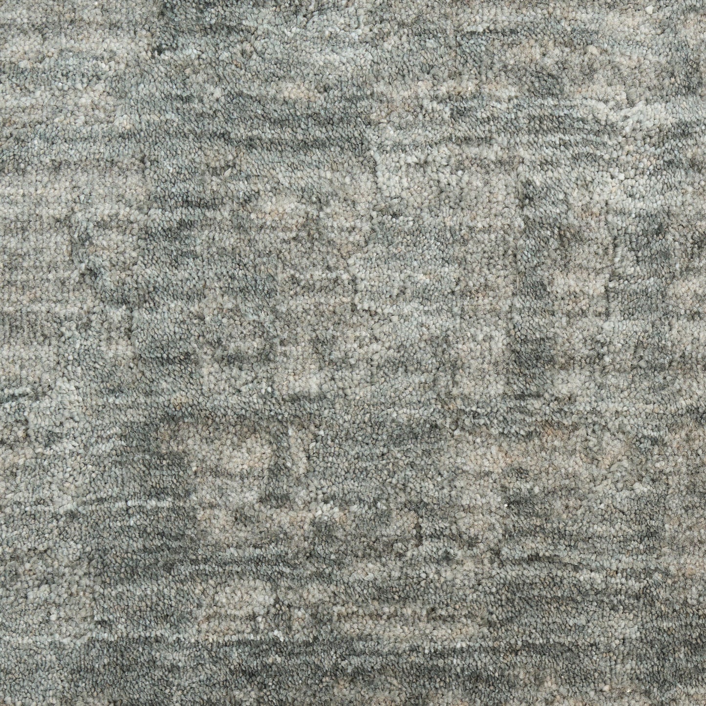 Close-up of grey speckled rug texture in muted tones; soft, plush loops with a subtle abstract pattern.