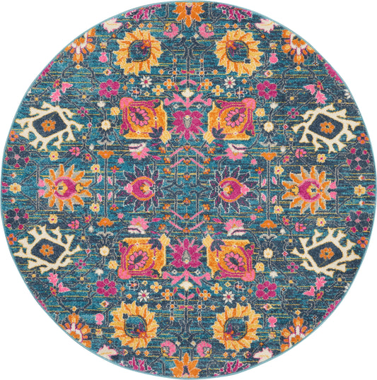 Round teal rug with vibrant multicolor floral and geometric motifs in pink, orange, yellow against a dark teal background.
