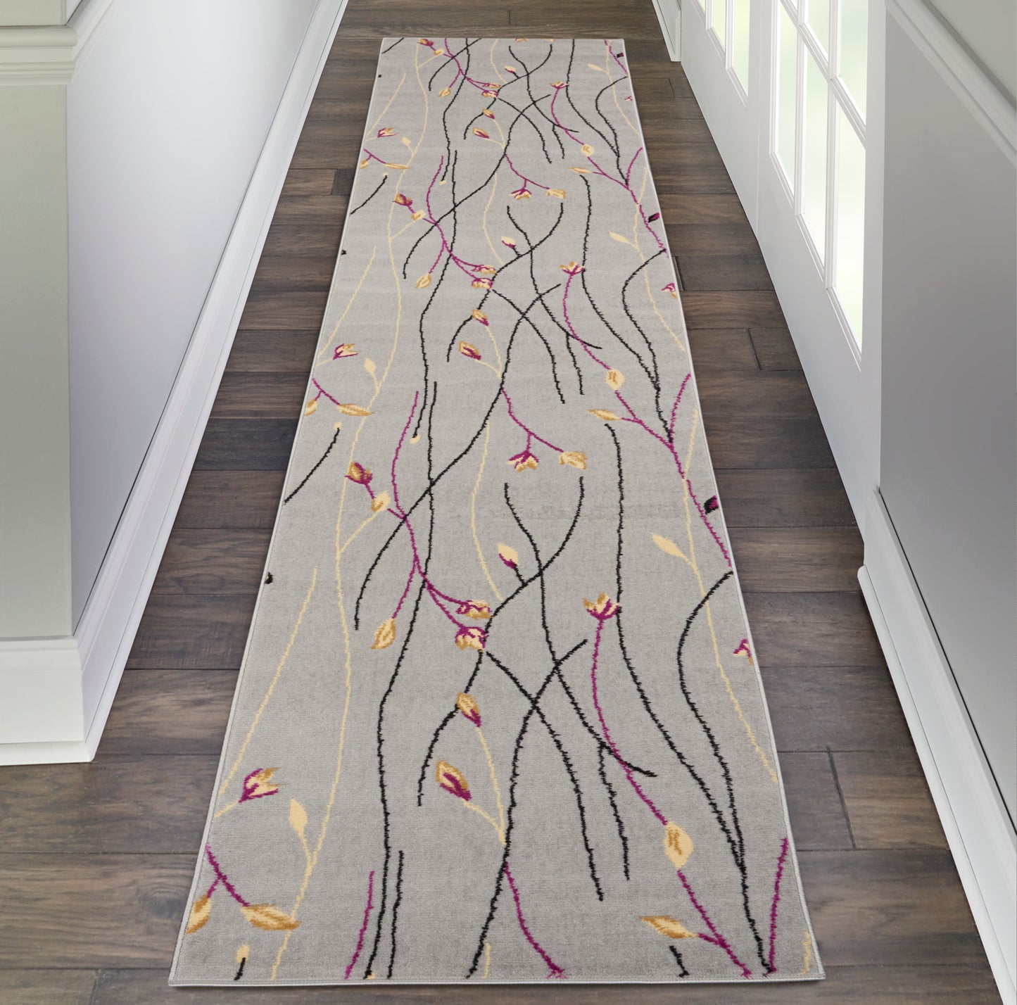 Gray hallway runner with abstract black, magenta and yellow vine lines and small leaves; long rectangular entryway rug.