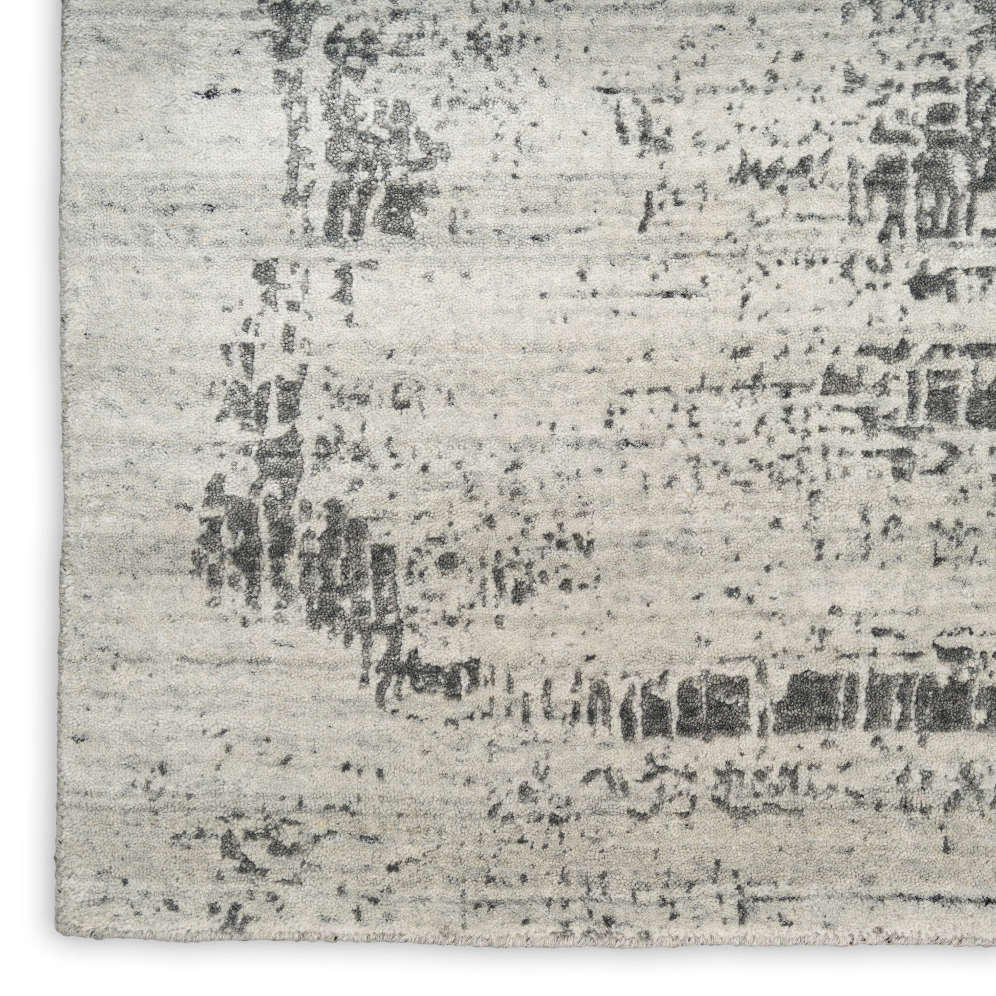 Light gray distressed area rug with abstract charcoal pattern; woven texture, modern rustic style.