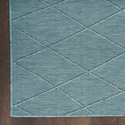 Teal diamond-quilted rug with textured weave and stitched border on wooden floor.