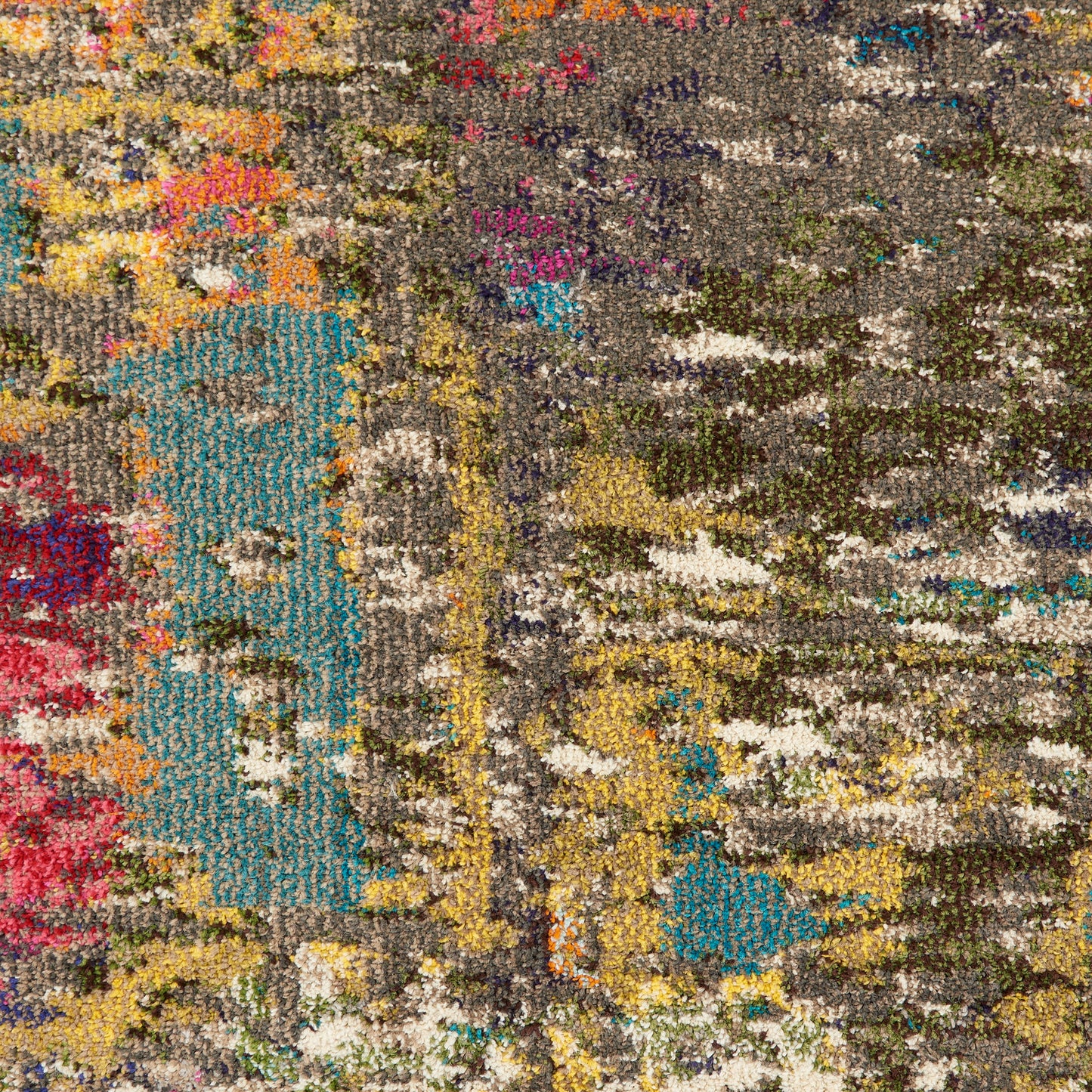 Close-up of a multicolor shag rug with teal, yellow, pink and gray in an abstract, textured pattern.