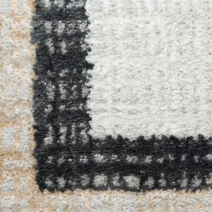 Plush shag rug with white center & bold black rectangular border; beige outer edge, modern geometric design.