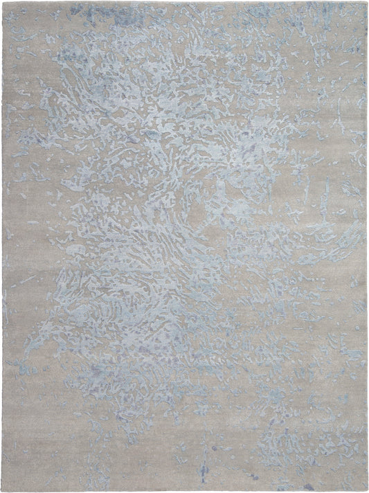 Beige area rug with pale blue-gray abstract pattern, modern textured surface, versatile for living spaces.