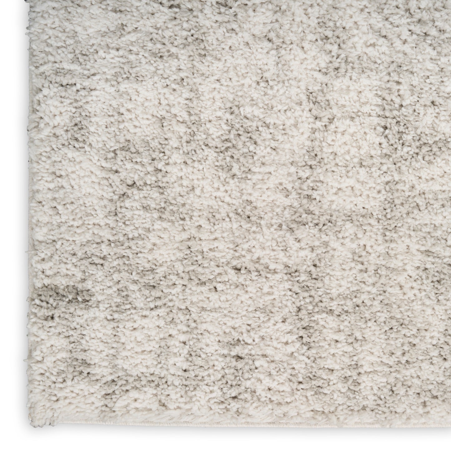Cream-beige shag rug close-up with dense plush pile and soft texture.