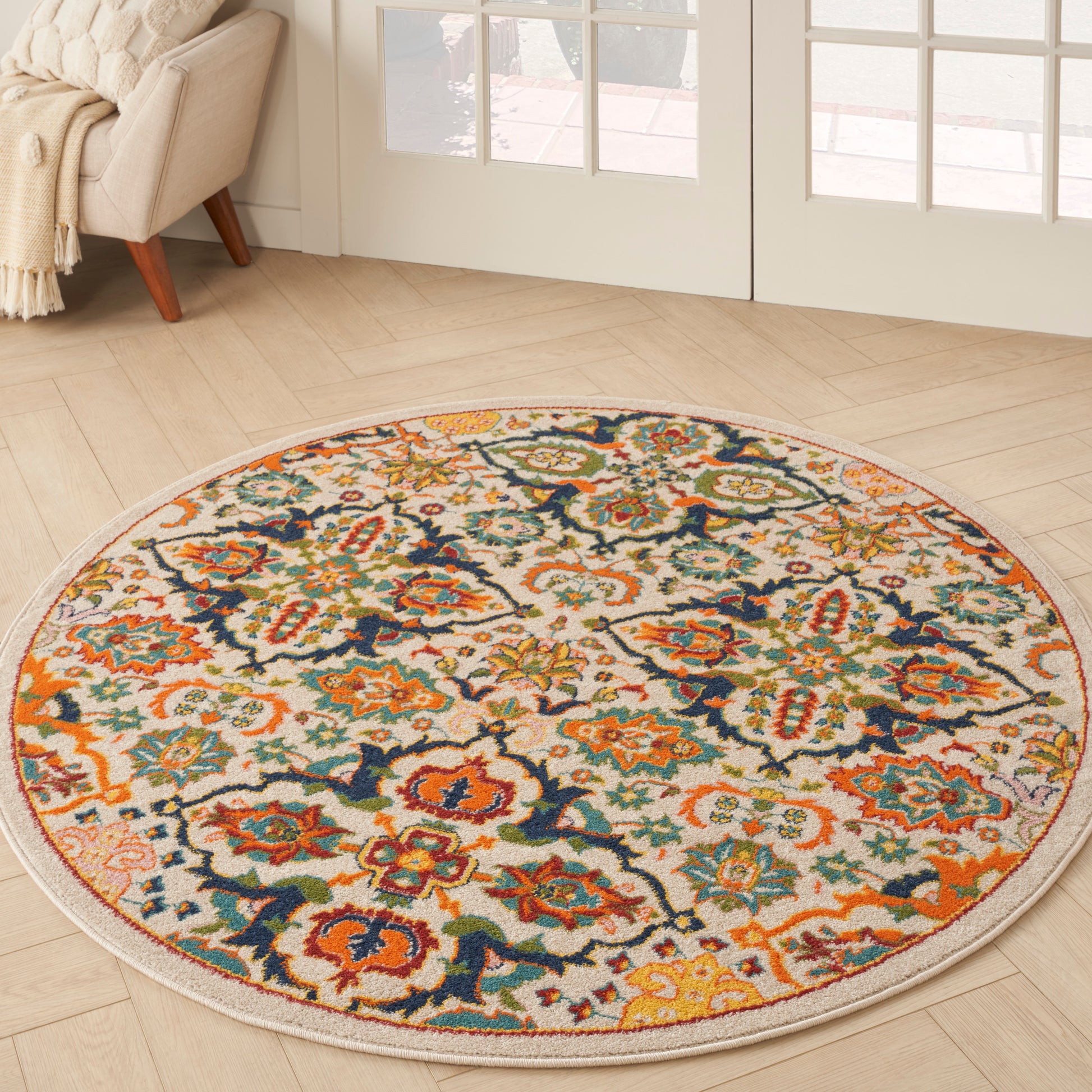 Round oriental-style rug with cream base and vibrant orange, teal, navy, and gold florals; cozy living room decor.