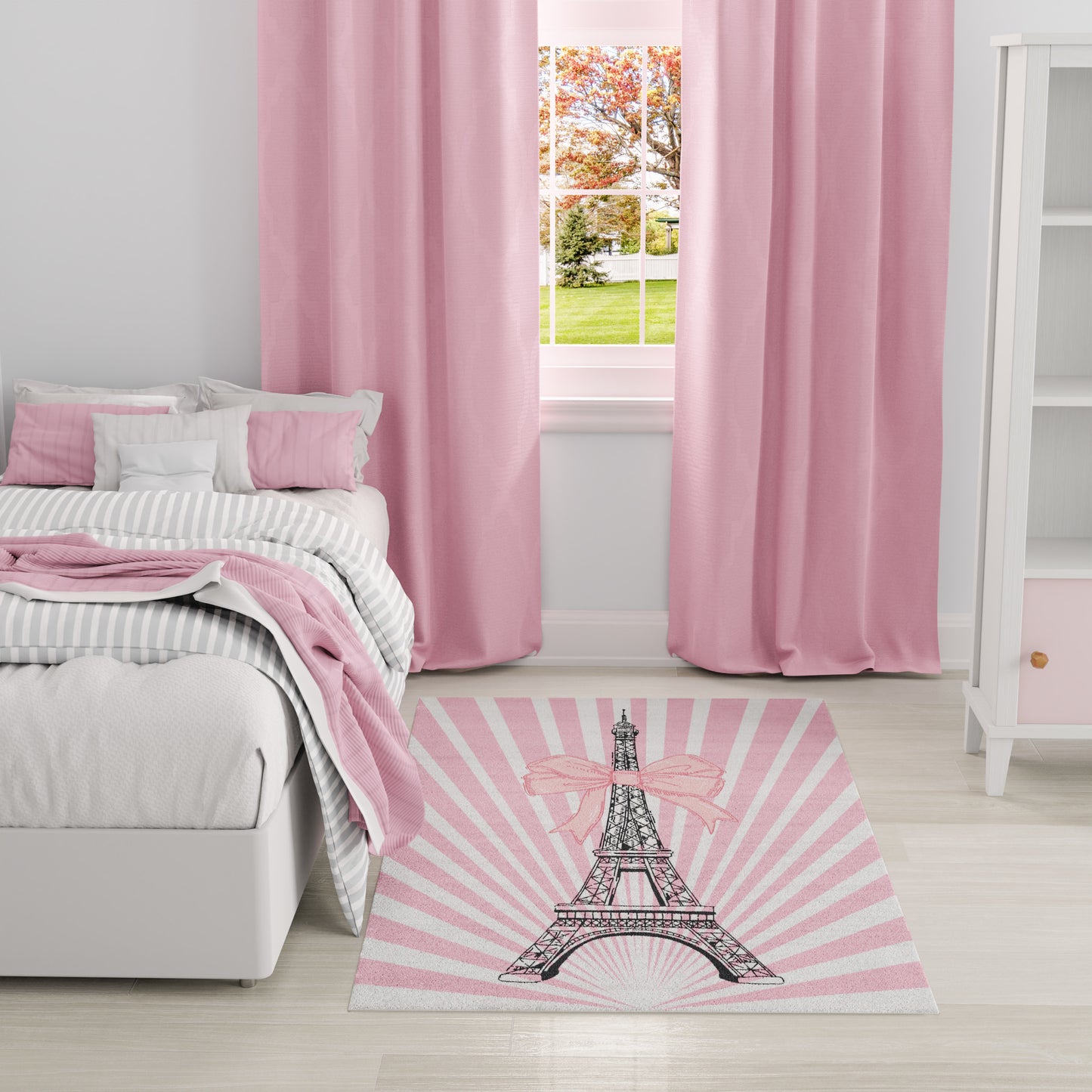 Pastel pink bedroom with pink curtains, striped gray bedding, and a pink rug featuring the Eiffel Tower.