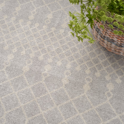 Gray rug with a pale beige diamond lattice pattern; soft woven texture beside a wicker plant basket.