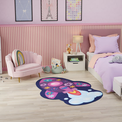Pastel pink kids' room with lavender bedding, pink tufted chair, white nightstand, and a purple flower rug with accents.