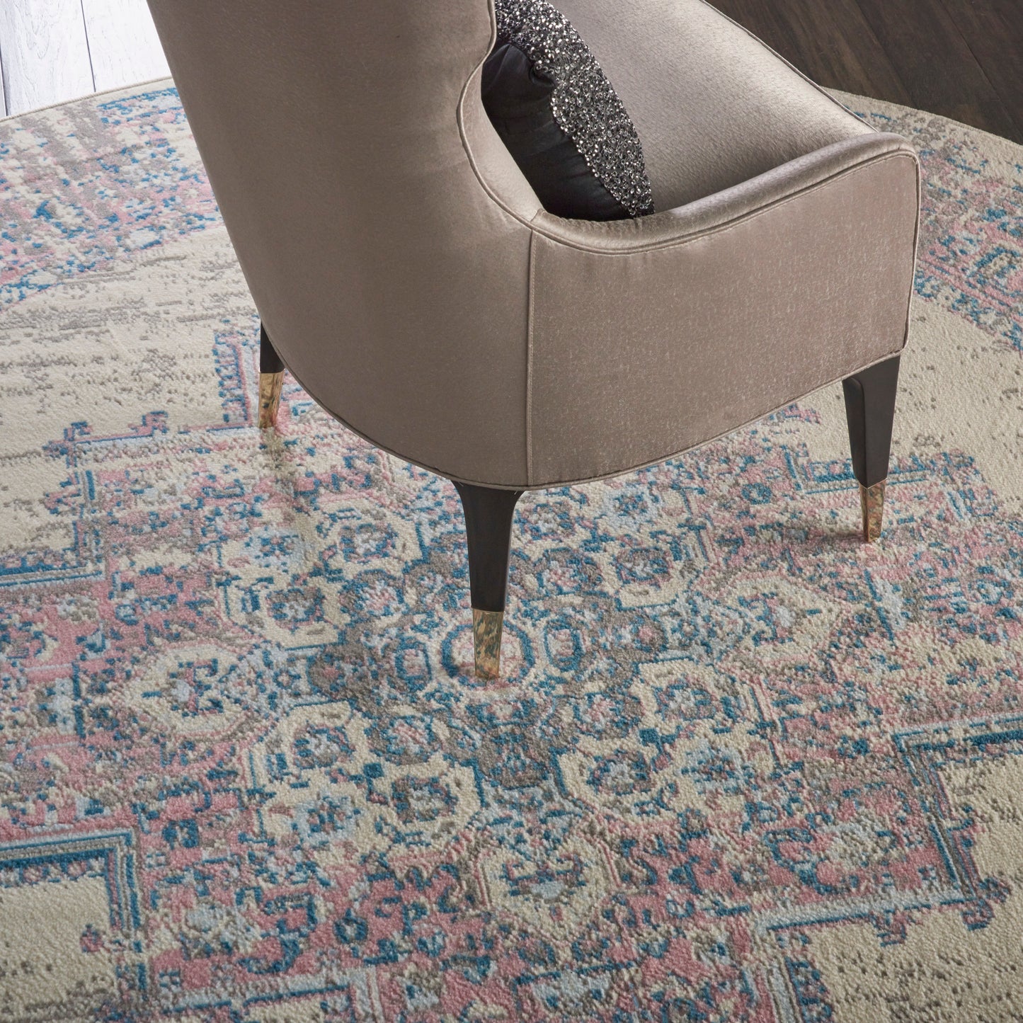 Round vintage beige rug with a pastel pattern; 8' diameter.