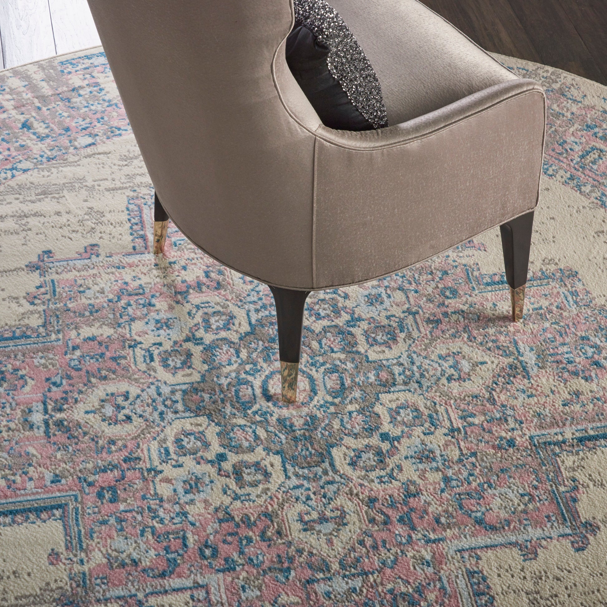 Round vintage beige rug with a pastel pattern; 8' diameter.
