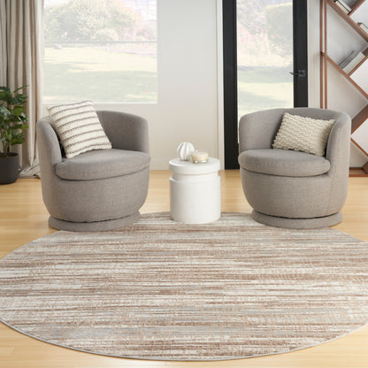 Two gray round lounge chairs with striped and textured cushions flank a white circular side table on a beige round rug.