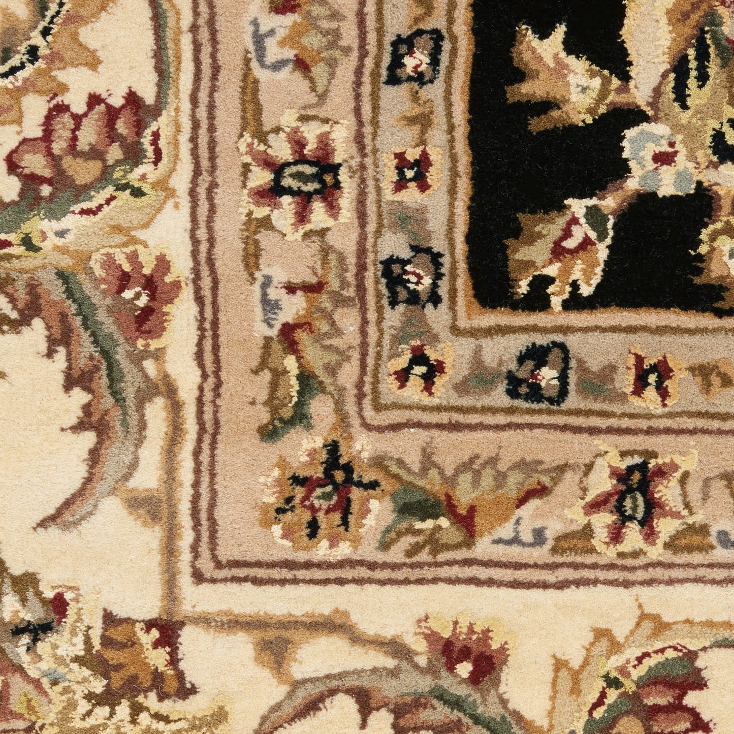 Persian-style area rug with beige-gold base, ornate floral border, red and green accents, and a dark central field.