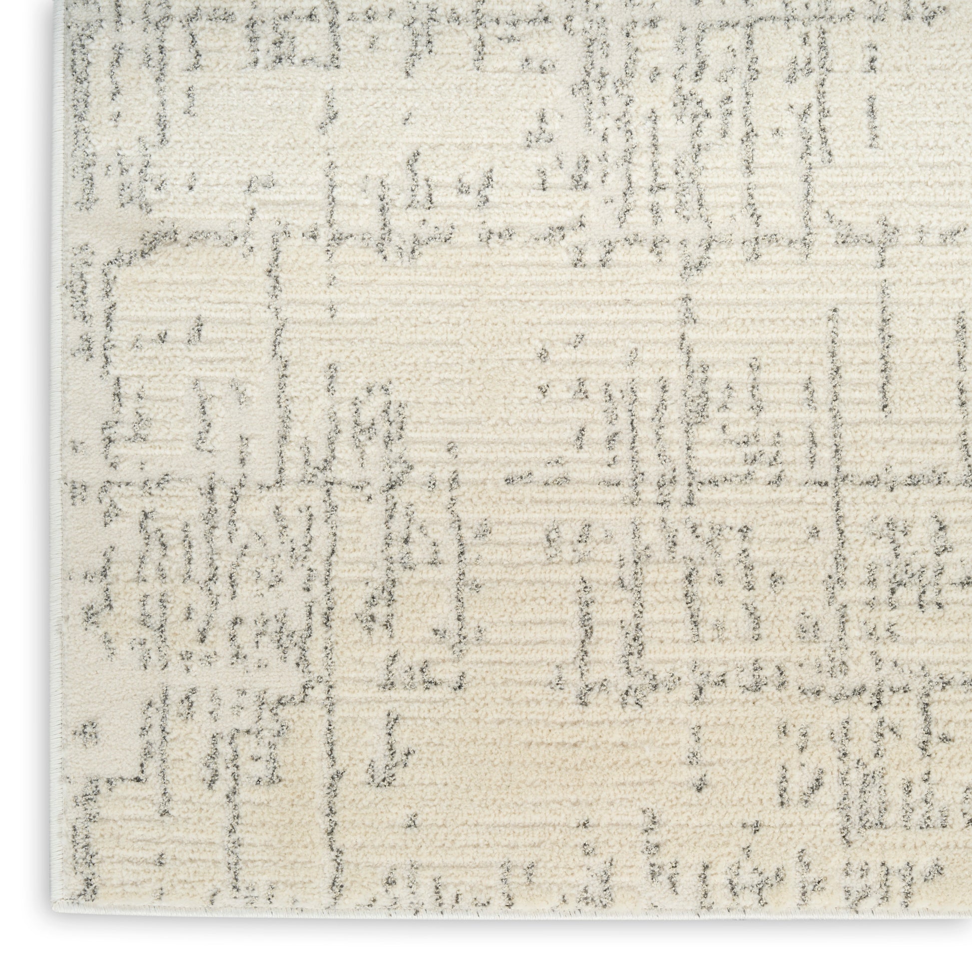 Rectangular cream area rug with subtle grey abstract geometric pattern and a soft, textured weave for modern neutrals.