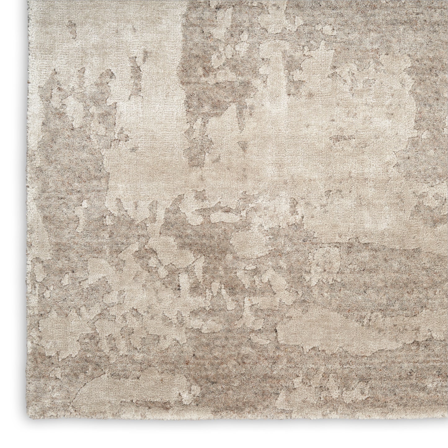 Beige distressed texture rug with abstract mottled pattern; soft woven surface.