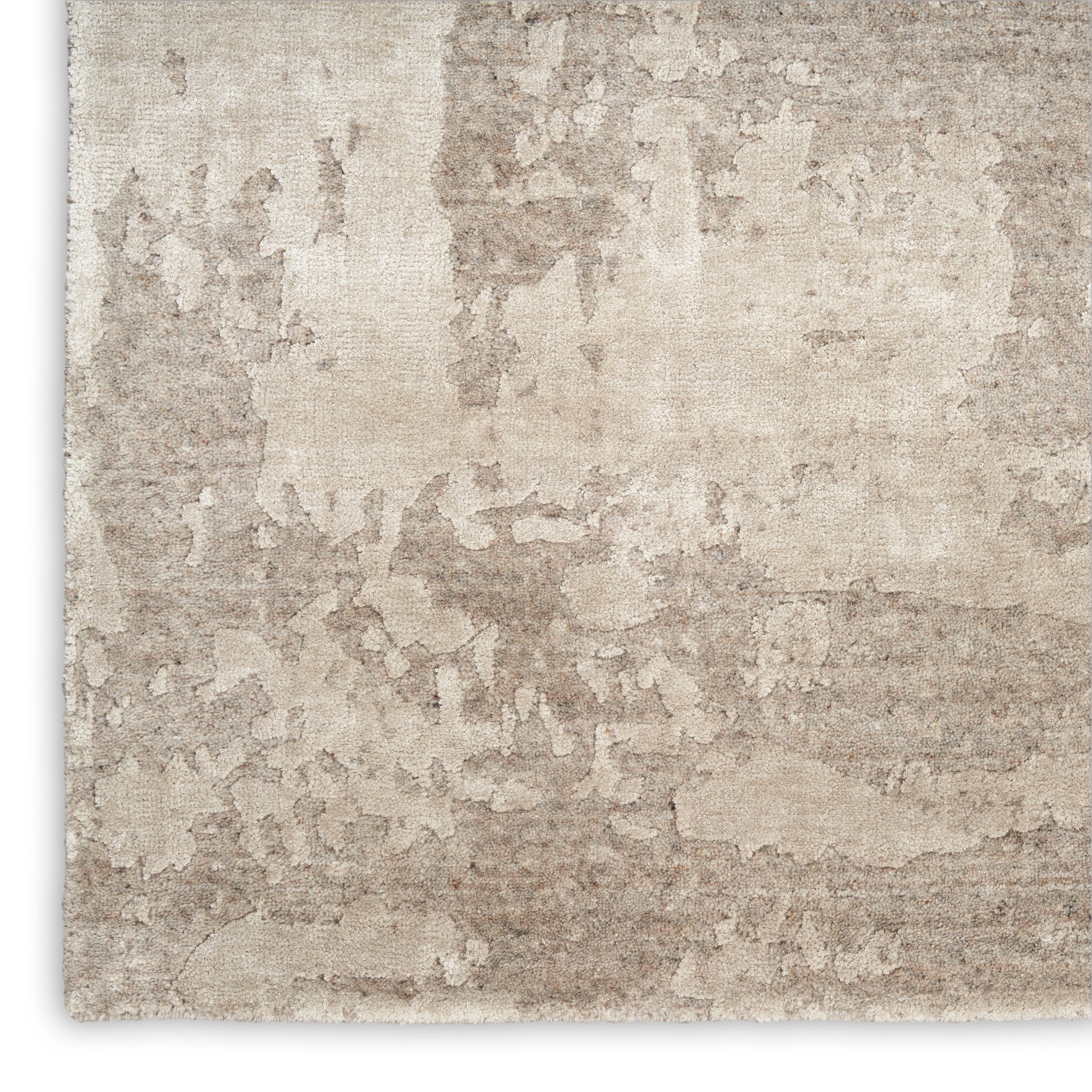 Beige distressed texture rug with abstract mottled pattern; soft woven surface.