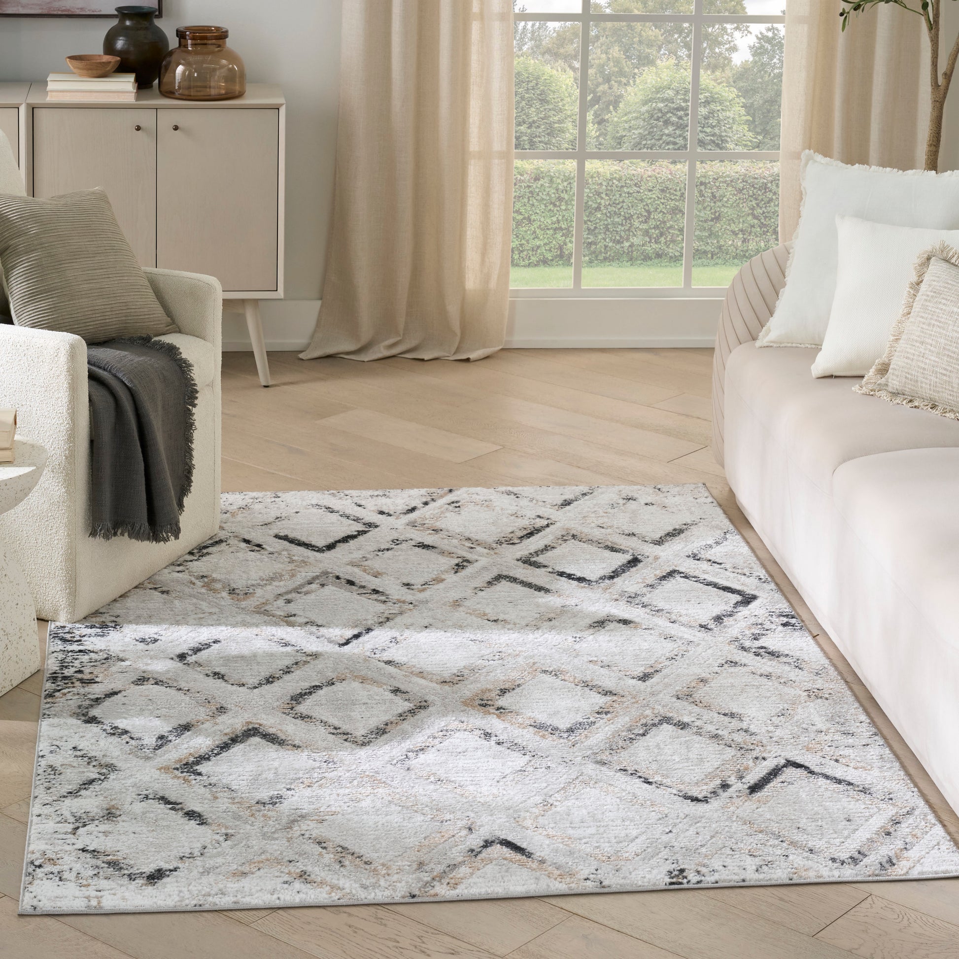 Soft gray rectangular area rug with black diamond lattice pattern and plush texture for a modern living room.