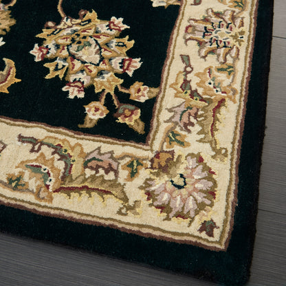 Traditional oriental rug corner with dark central field, ornate floral border in cream and gold, rectangular floor decor.