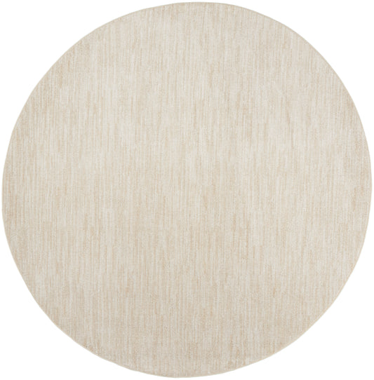 Round beige outdoor rug with subtle linear texture; soft, neutral woven floor covering for outdoor spaces.