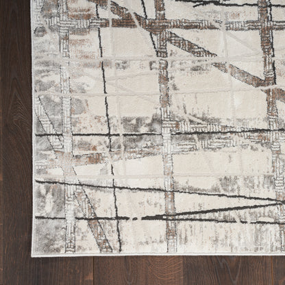 Modern abstract area rug in beige, ivory, gray and brown with grid-line geometric pattern on dark wood floor.