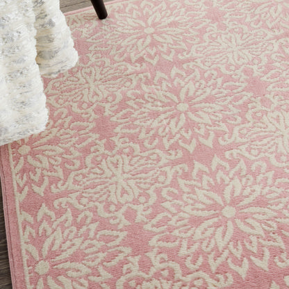 Pink area rug with cream floral pattern, plush woven texture and border detail.