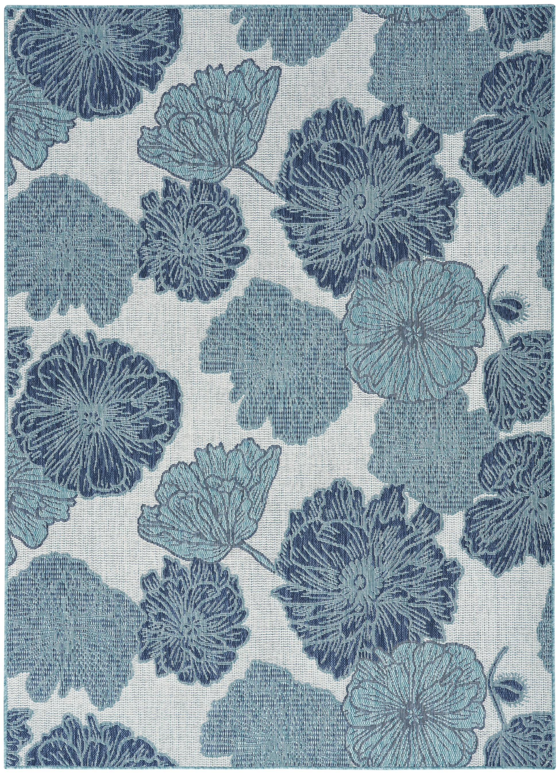 Blue floral textile with large blossoms and textured petals on a pale background; decorative upholstery fabric.