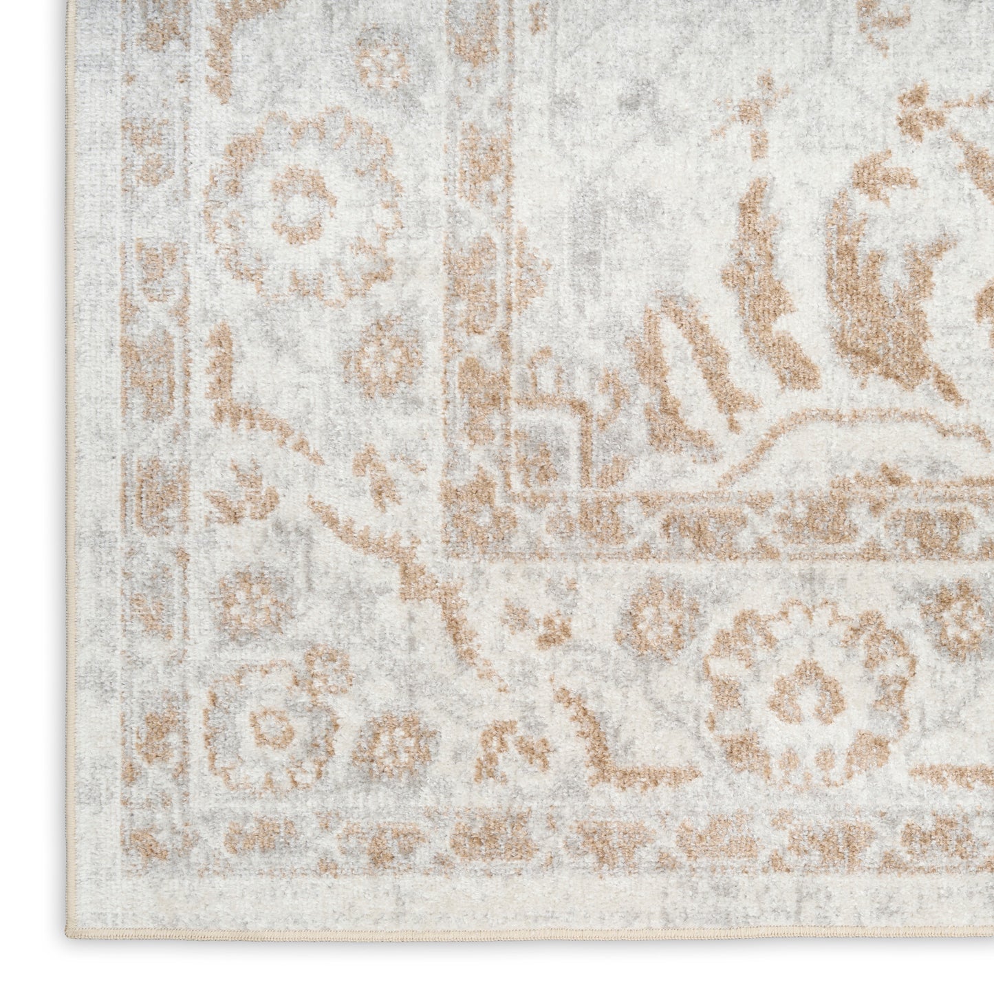 Rectangular area rug in ivory and warm tan with a distressed Persian floral medallion and border.