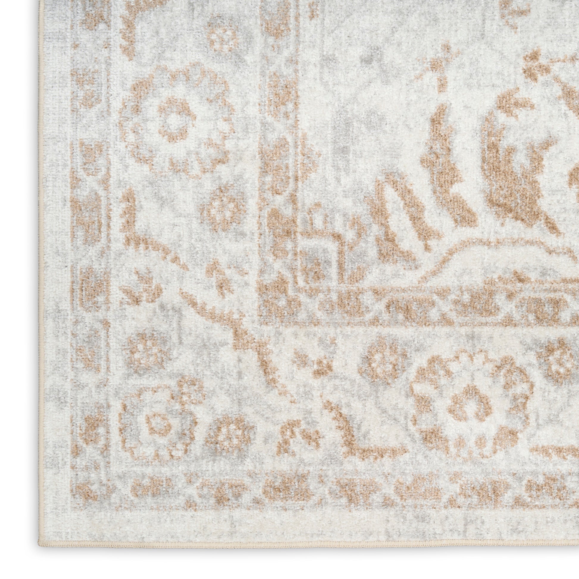 Rectangular area rug in ivory and warm tan with a distressed Persian floral medallion and border.