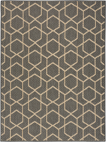 Dark charcoal rug with cream hexagon lattice pattern; woven, textured surface in a modern geometric hex grid style.