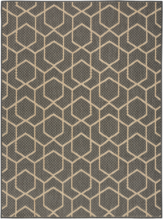 Dark charcoal rug with cream hexagon lattice pattern; woven, textured surface in a modern geometric hex grid style.