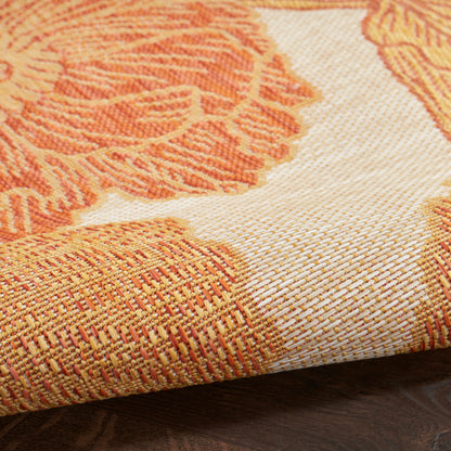 Close-up of orange and cream woven rug with textured floral geometric pattern, 3' x 5', rolled corner on wood floor