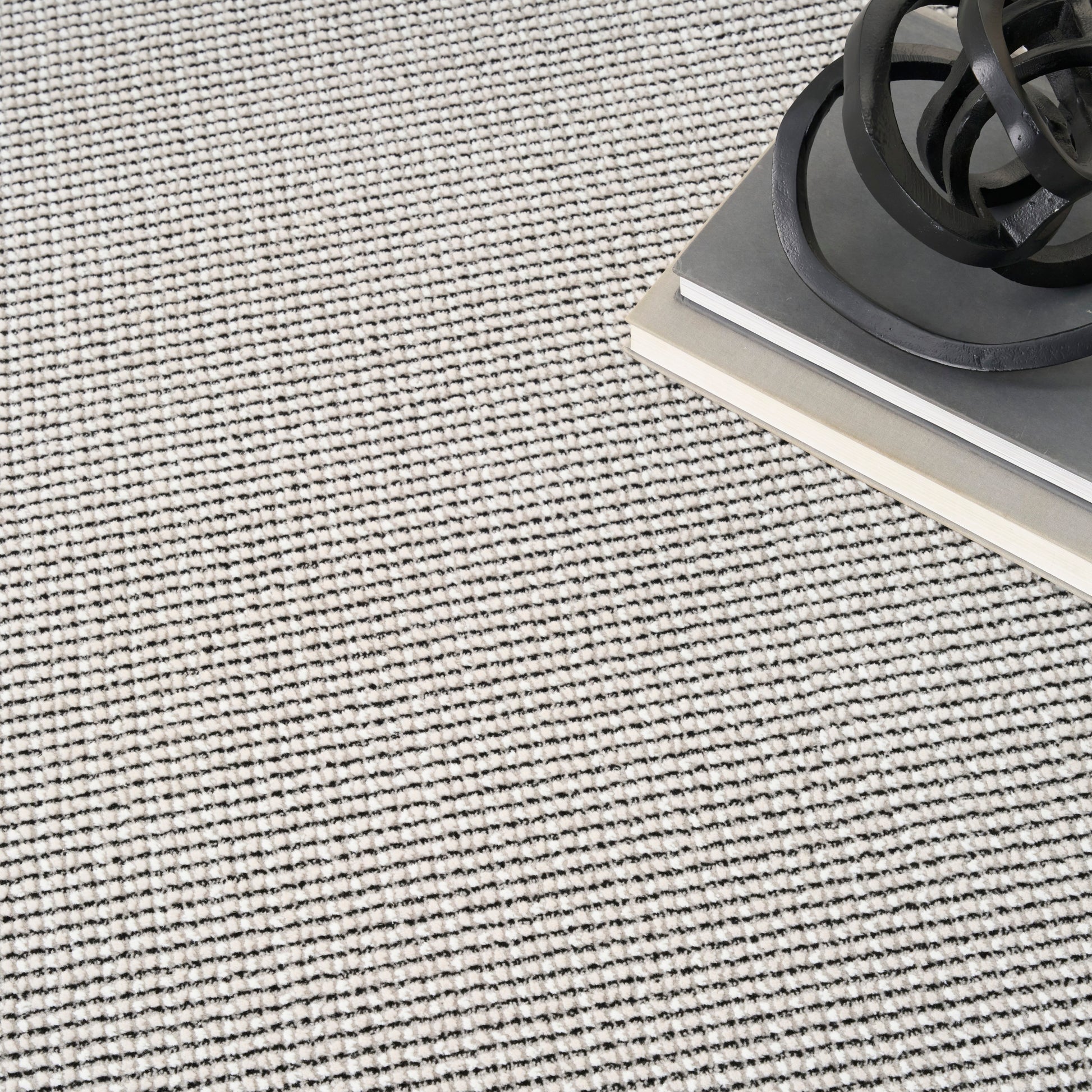 Beige-gray textured woven rug with tight loop pattern & contemporary floor covering for living spaces.