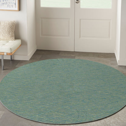 Round teal flat-weave rug with pale yellow lattice diamonds for entryway.
