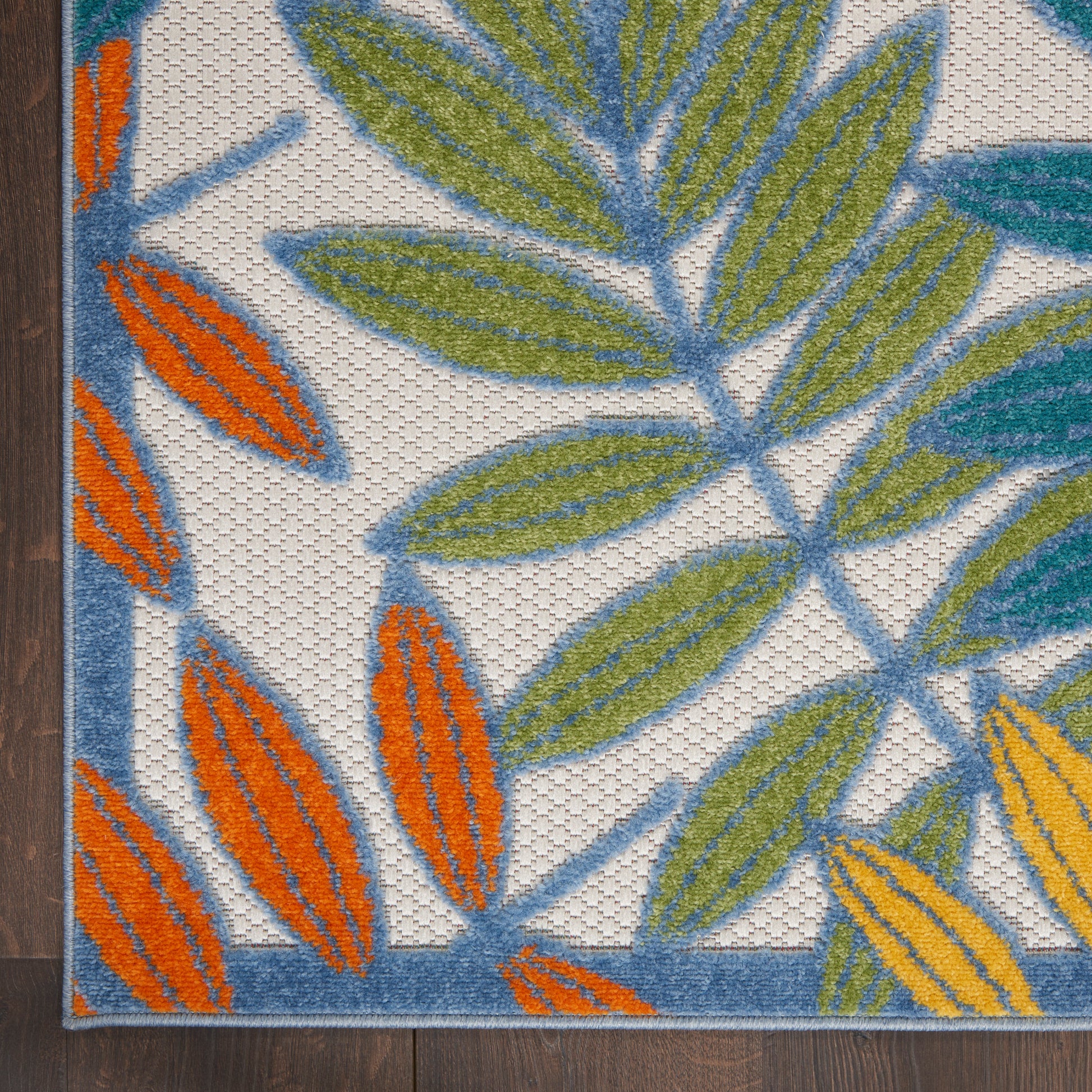 Textile panel with green and orange leaf motifs on a light background, blue trim and wood edge.