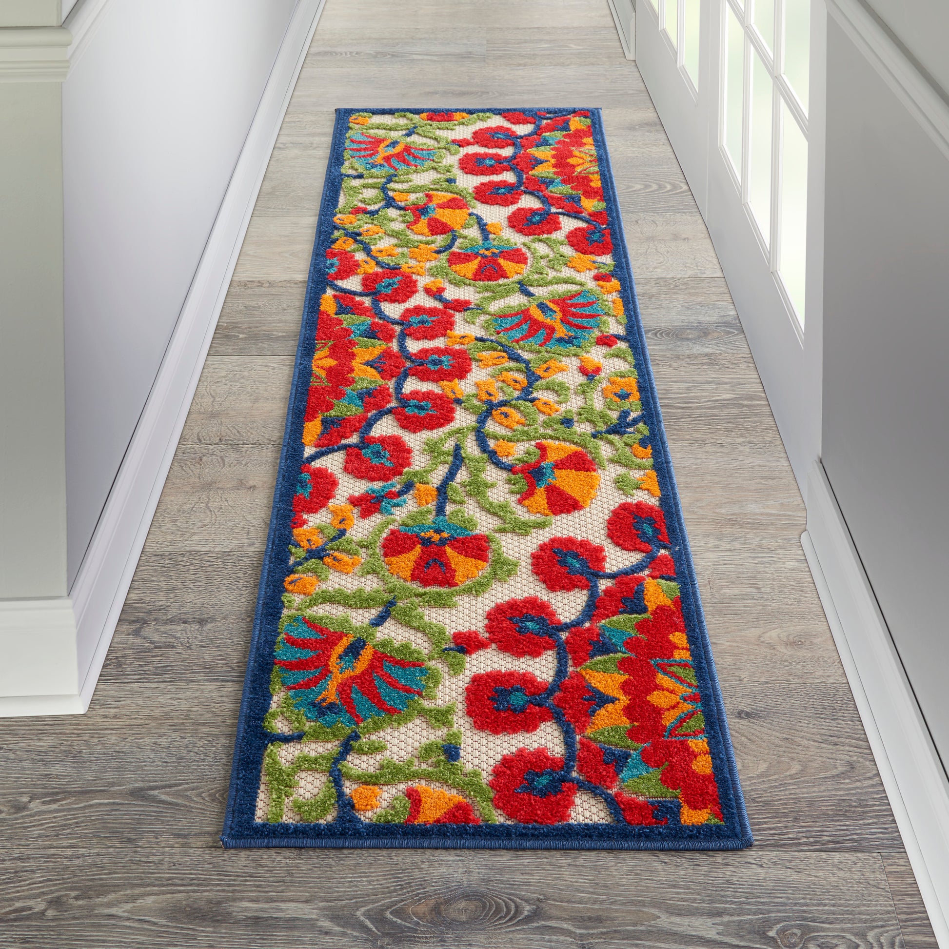 Colorful floral runner rug with red, yellow, blue & green flowers on cream, blue border, rectangular hallway mat.