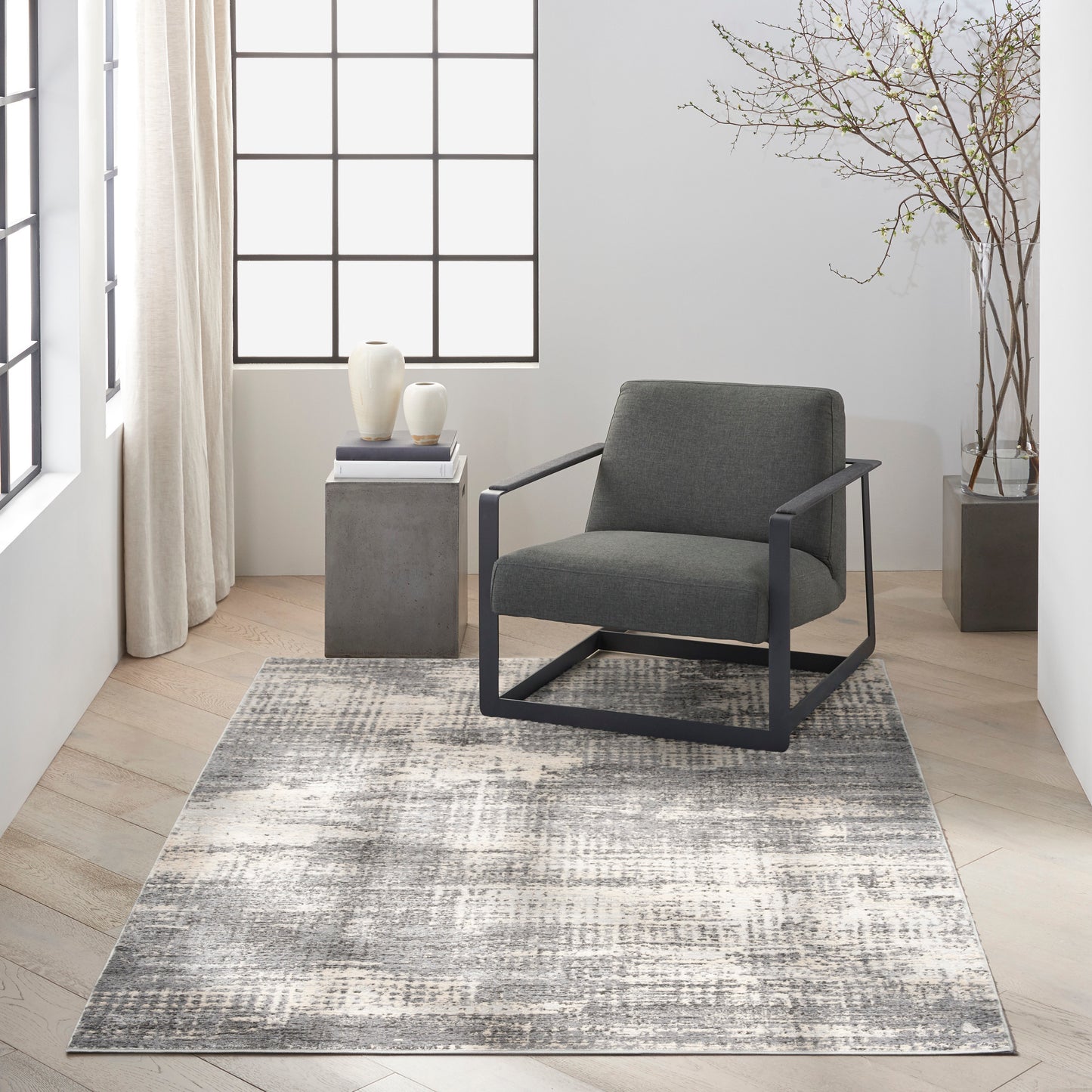 Modern gray rug, 5' x 7', in a bright minimalist living room.