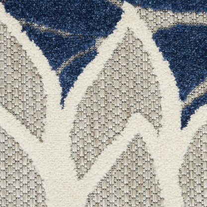 Close-up of a textured beige rug with an off-white lattice pattern and navy blue geometric shapes.