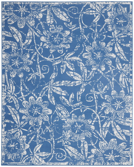 Blue rug with an intricate white floral damask pattern of vines and blossoms.