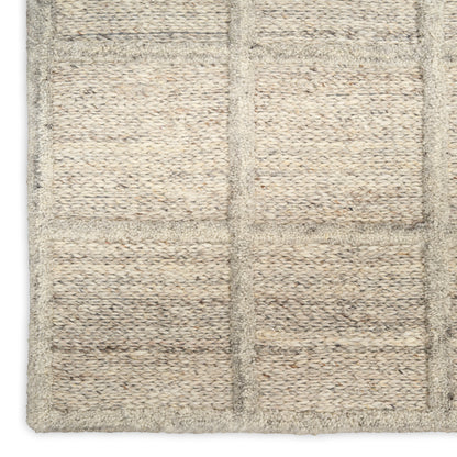 Beige woven rug with a grid of rectangular panels in a natural fiber texture.