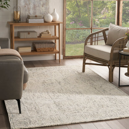 Neutral living room with cream woven rug, wicker chair, gray sofa, wooden shelf with baskets, sunny garden view.