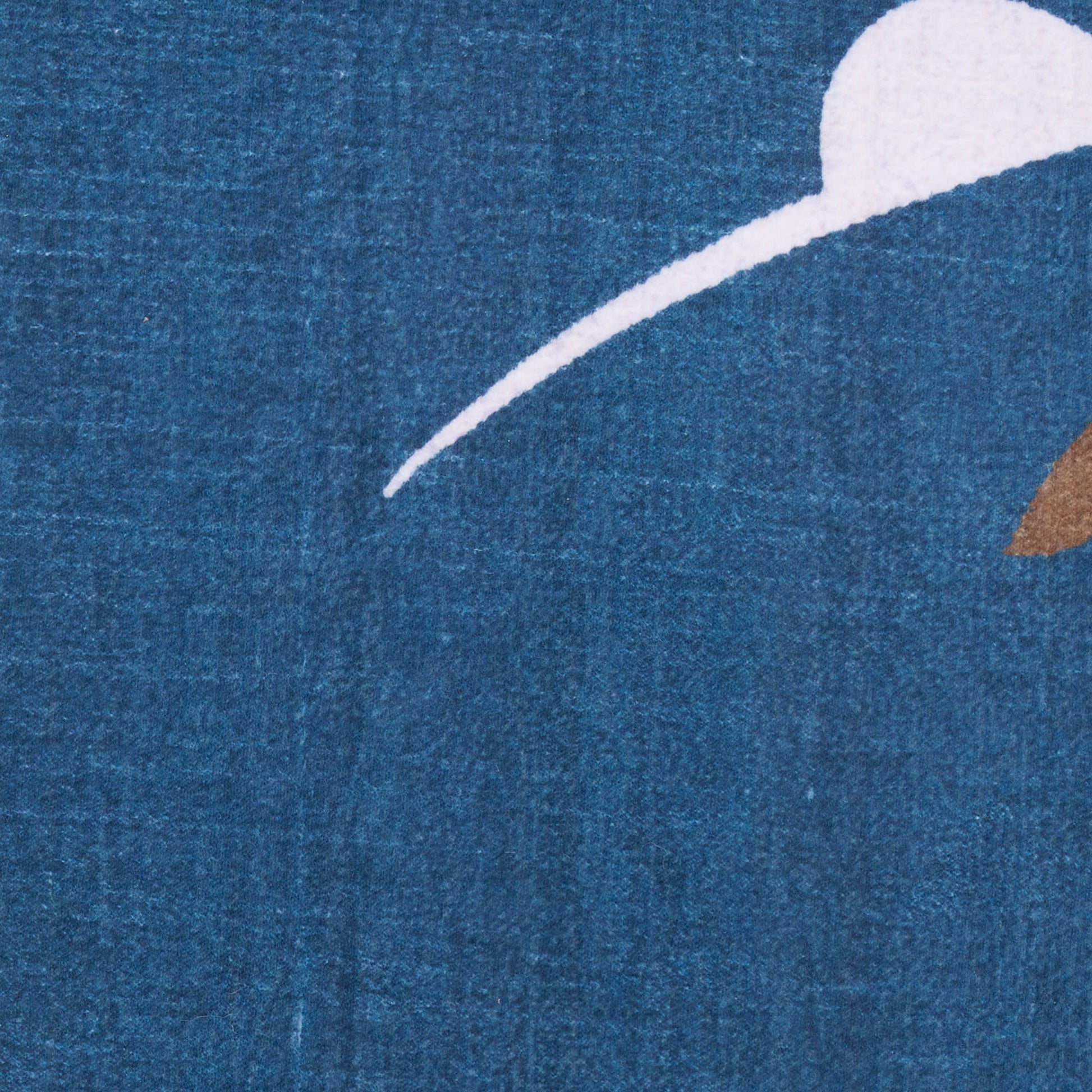 Close-up of blue textured rug with a white curved arc, partial white circle, and a brown triangular accent.